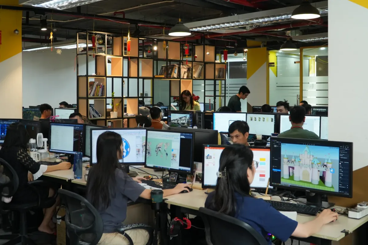 Không gian làm việc với nhiều người ngồi trước các màn hình máy tính.