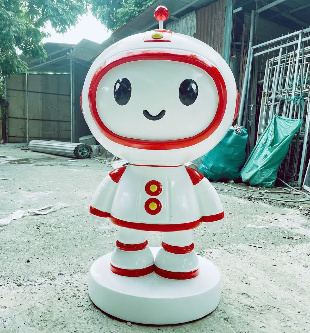 Hình robot màu trắng đỏ có đầu tròn, gương mặt cười và tay hơi mở sang hai bên