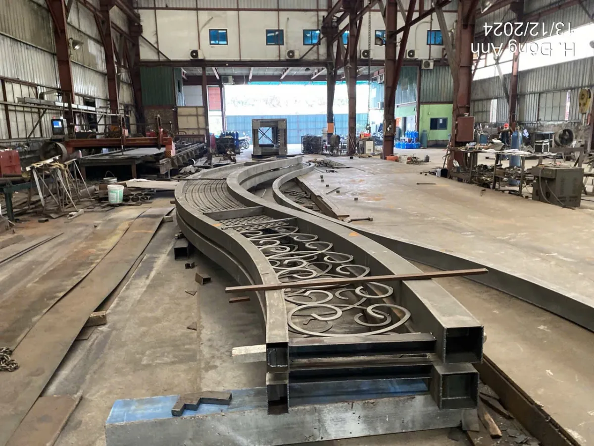 Các cấu kiện cong có hoa văn đặt nằm trên sàn xưởng.