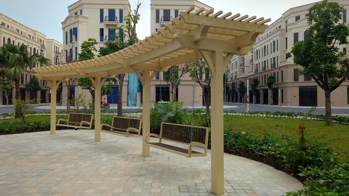 Ba ghế treo dưới giàn pergola màu kem trong khu cảnh quan