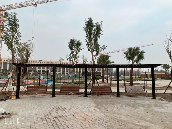 Toàn cảnh hệ mái dài và bốn ghế xích đu bố trí trên nền sân lát gạch