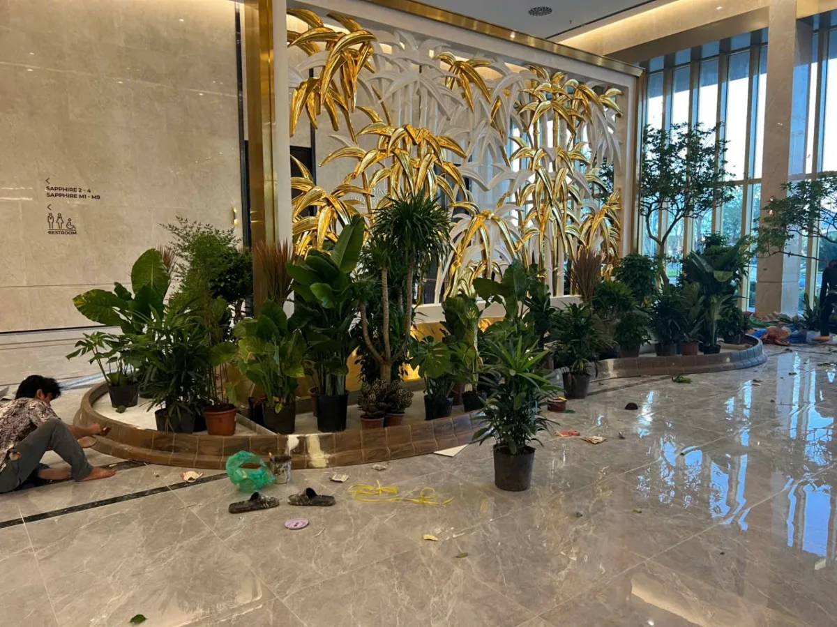 Tổ hợp hình lá ánh kim trên khung cùng cây tại sảnh