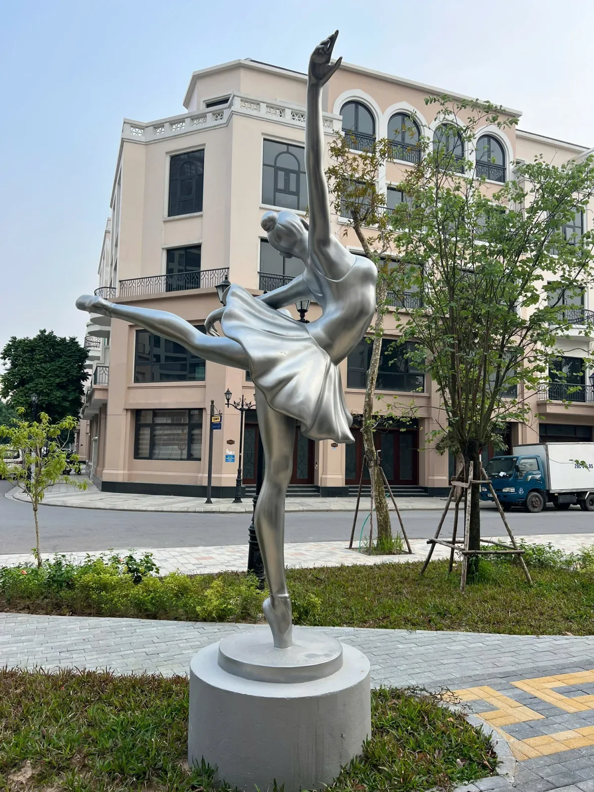 Tượng người múa vươn một tay lên cao trên bệ tròn