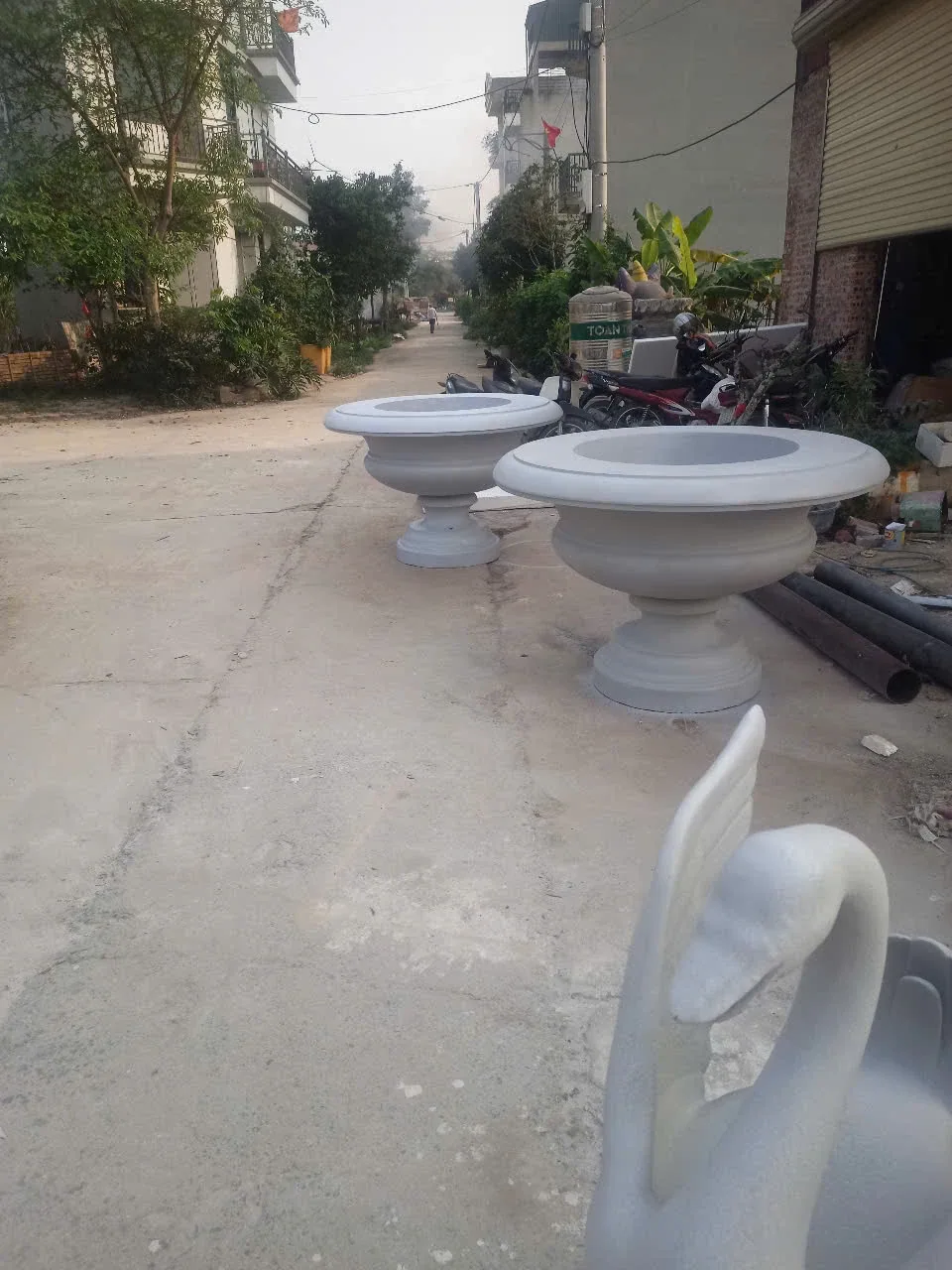 Các vật thể dạng bồn và đài trang trí được đặt cạnh nhau