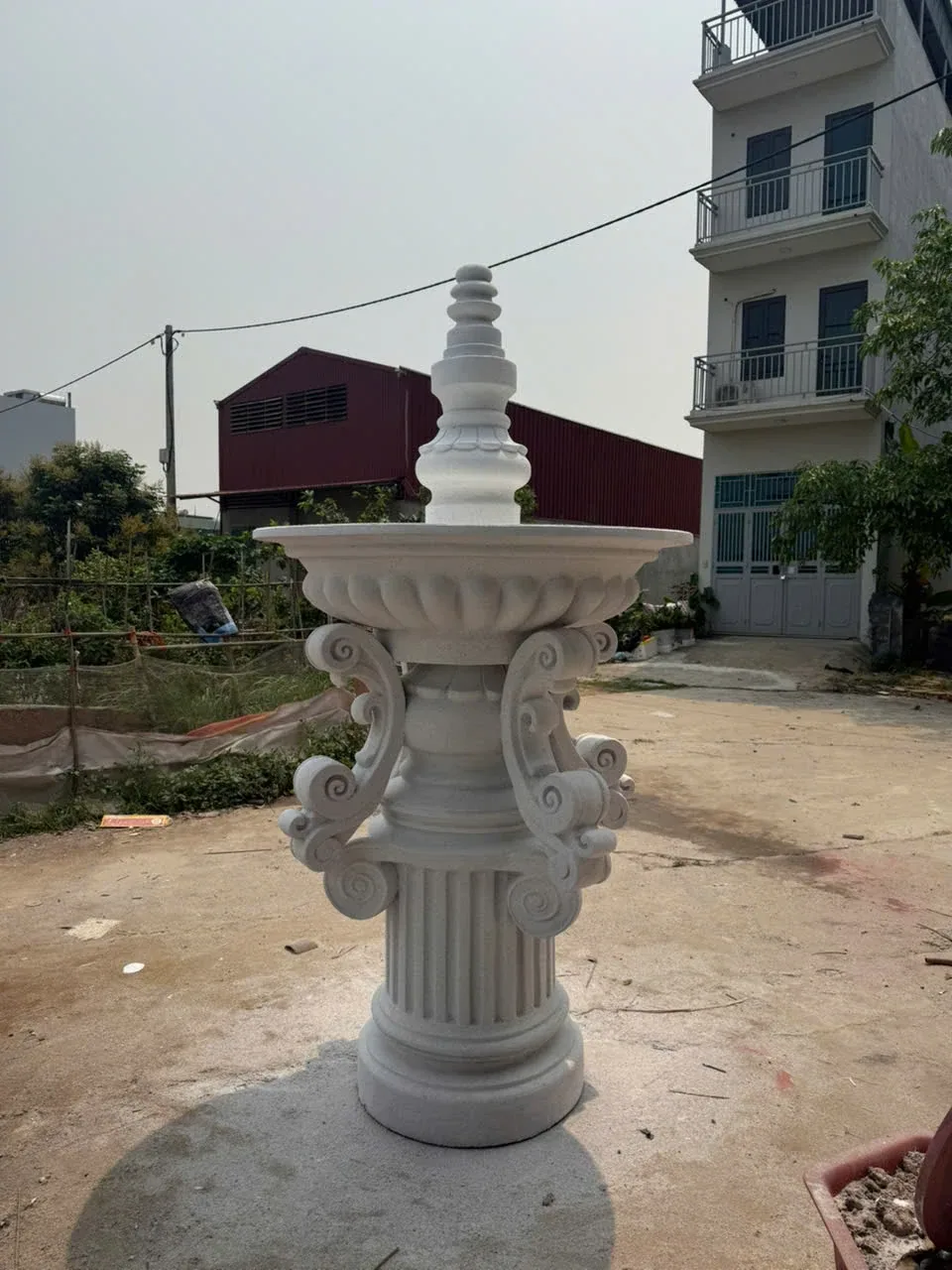 Khối trang trí đứng màu sáng với chân có rãnh và phần trên nhiều tầng