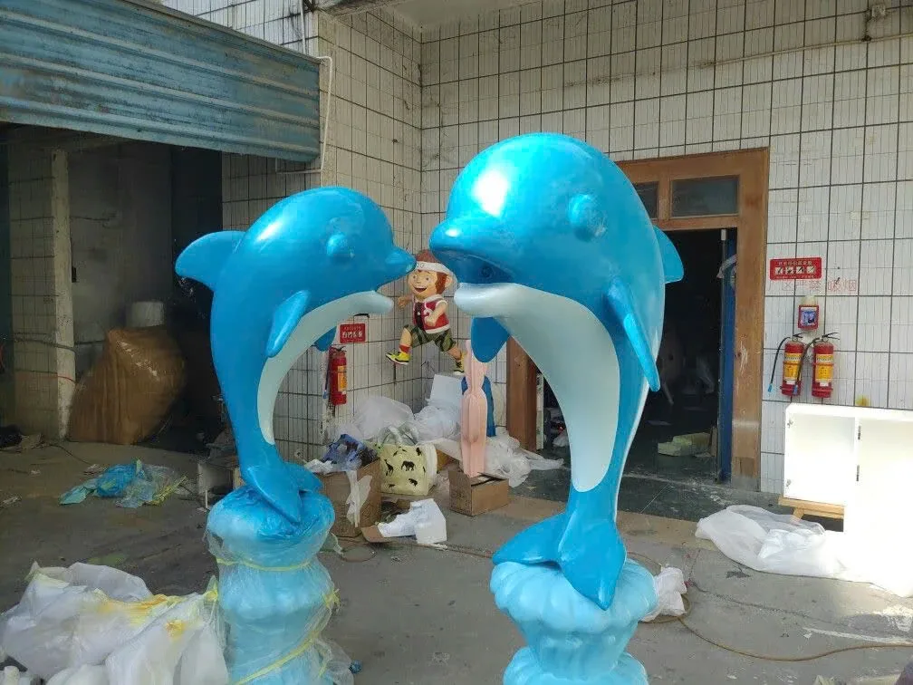 Hai hình cá heo màu xanh hướng vào nhau trên các phần nền gợi sóng