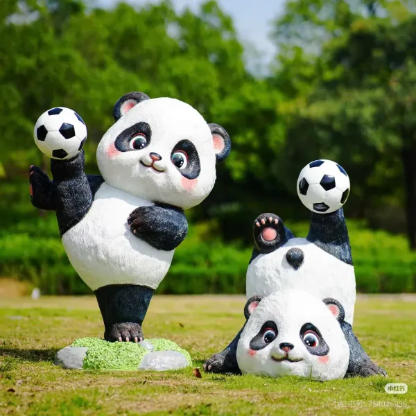 Ba tượng gấu trúc tạo dáng với hai quả bóng đá trên bãi cỏ