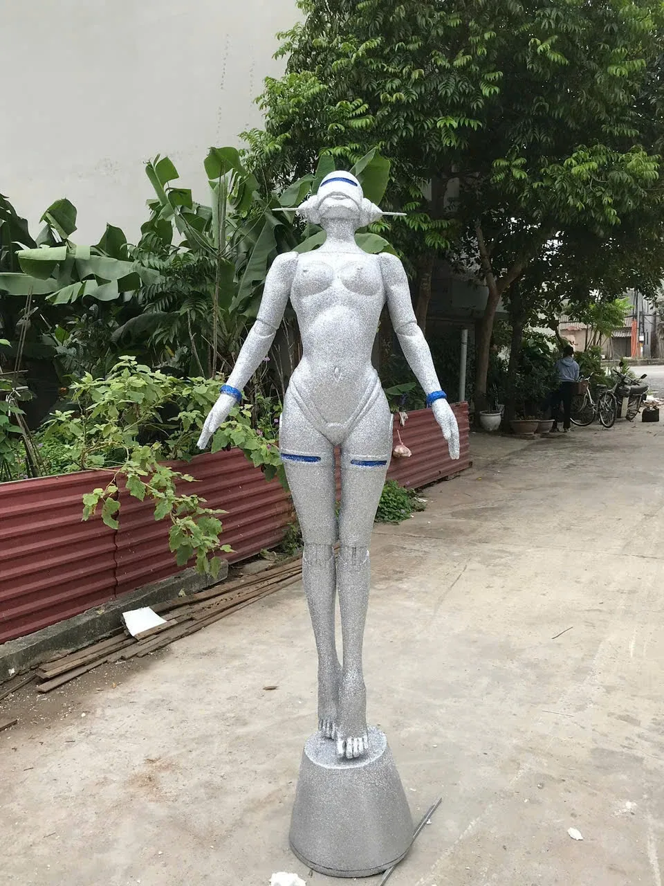 Tượng nhân vật có bề mặt ánh bạc đứng trên bệ nhỏ