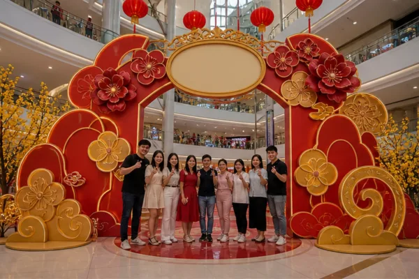 Cụm cổng check in Tết bằng composite đặt tại sảnh trung tâm thương mại với logo thương hiệu và khu vực khách chụp ảnh nhóm
